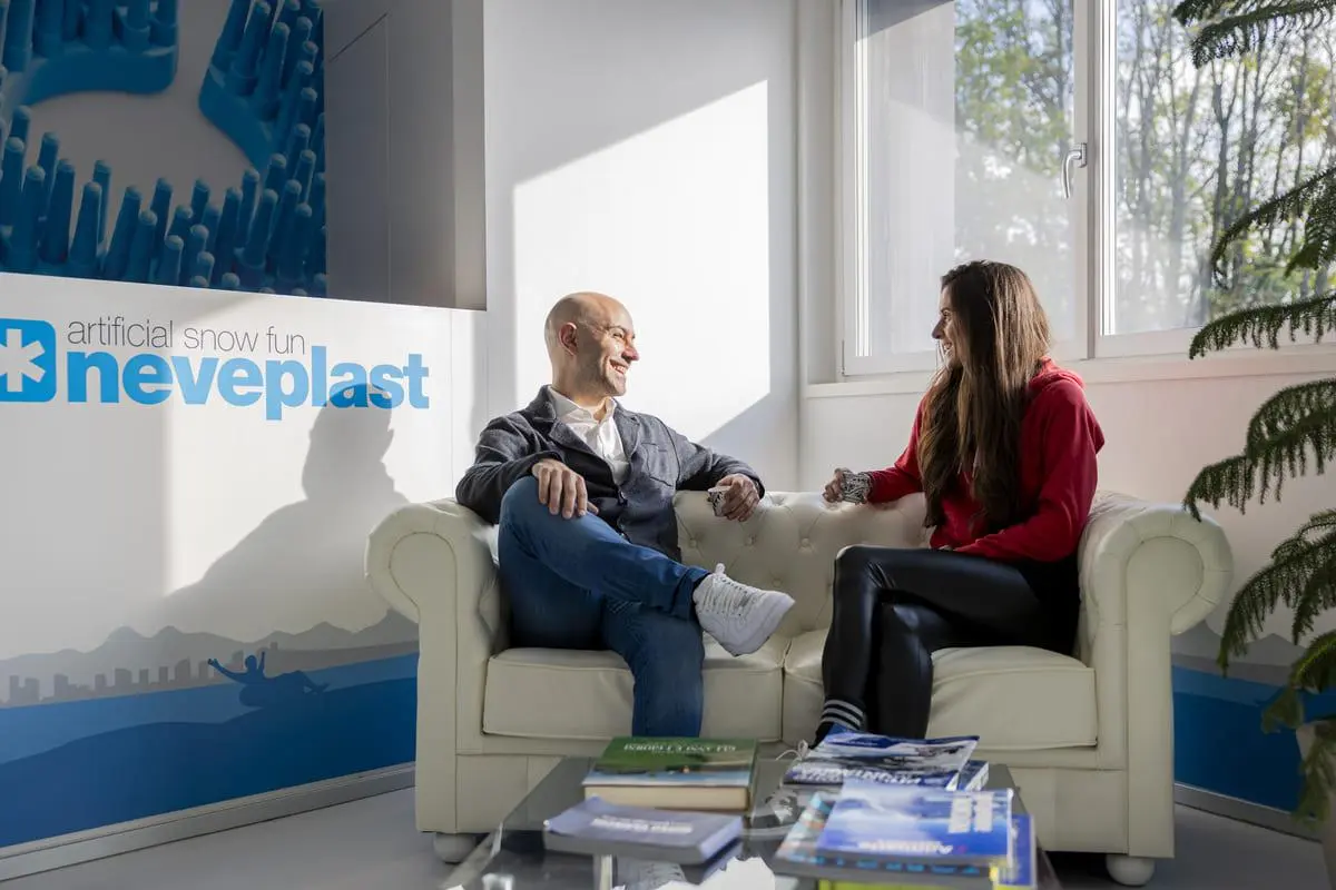 图中展示 Neveplast 办公室内舒适的沙发洽谈区，适合团队讨论项目或与客户沟通。